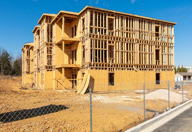 a temporary chain link fence winding around a construction site, outlining the project's progress in Illiopolis IL